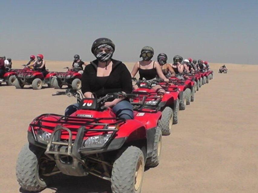 Quad bikes parked in Luxor’s Eastern Desert near palm trees, ready for safari adventure.