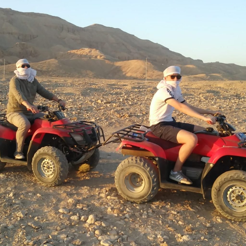 Adventure seekers riding quad bikes in the Luxor desert.