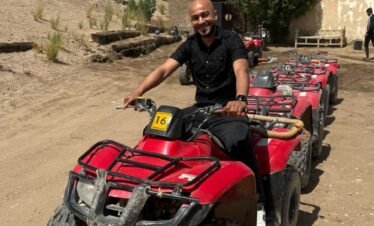 Quad bikes parked in Luxor’s Eastern Desert near palm trees, ready for safari adventure.