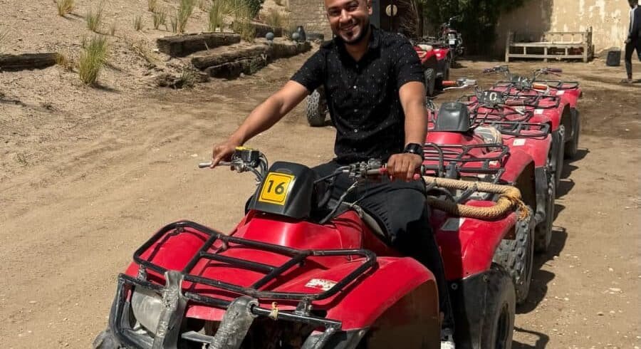 Quad bikes parked in Luxor’s Eastern Desert near palm trees, ready for safari adventure.